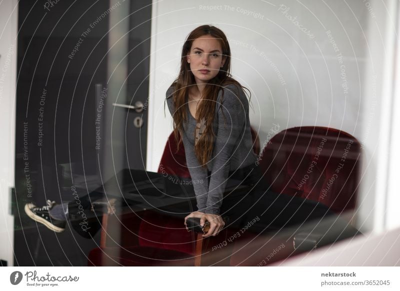 Young woman in Splits Position Across Red Velvet Armchair armchair female one person girl young woman velvet model indoors glass reflection looking at camera