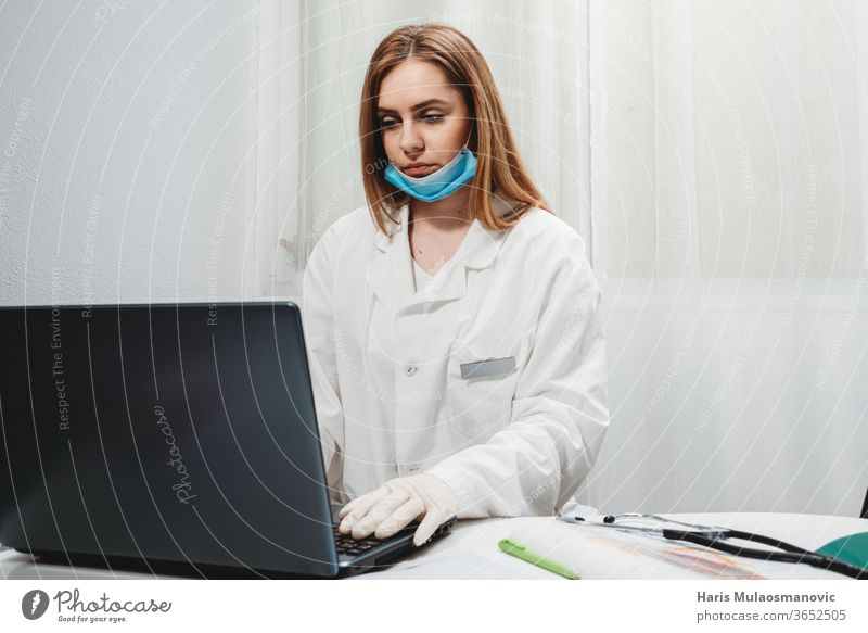 Female doctor with mask working on laptop in the doctors office teledoctor 2020 air mask black background clinic corona epidemic corona virus covid-19