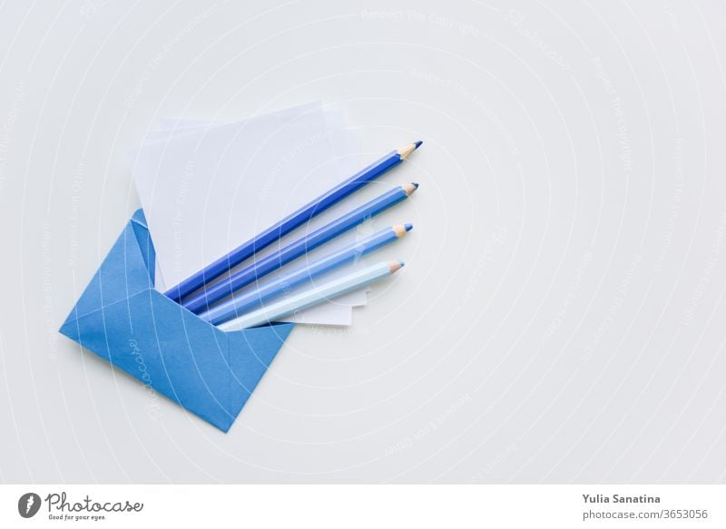 selective focus, blue pencils and white papers out of the blue envelope with copy space on top sheet background message blank letter office empty note
