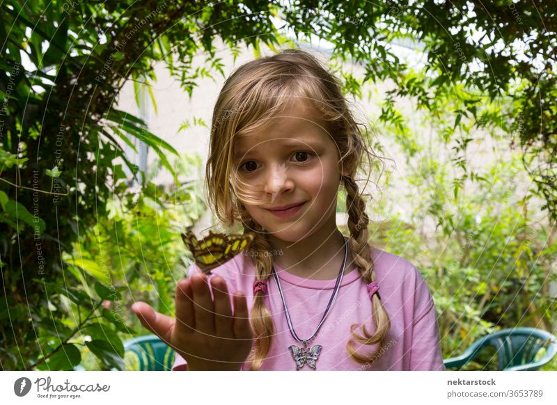 Low Angle View of a Child With Butterfly on Fingertips butterfly girl child portrait fingertips low angle view close up outdoor nature beauty in nature blond