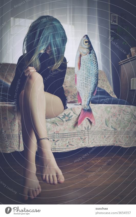 teenager with wig sitting on a sofa next to a fish date with fish foot Legs Film worthy Funny Looking youthful Idea History of the Wig Whimsical Puberty Strange