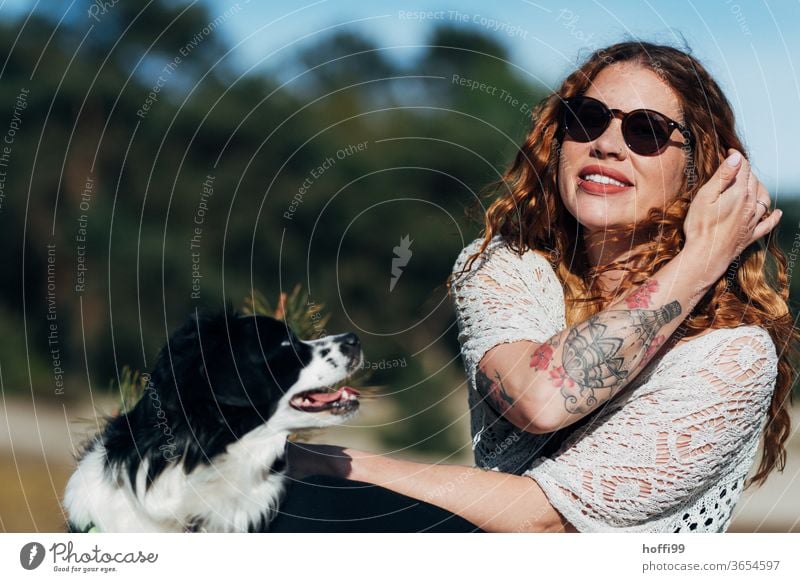 the young woman with sunglasses is enjoying the sun, Lana her dog wants to play... Woman red lips Sunglasses tattooing pretty Youth (Young adults) curly hair