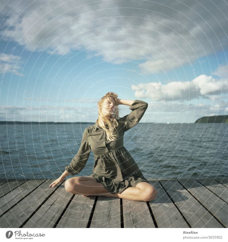 analogue full body portrait of a young, blond, barefoot woman on a wooden jetty in the sea Woman Young woman Blonde already Slim Long-haired windy Esthetic