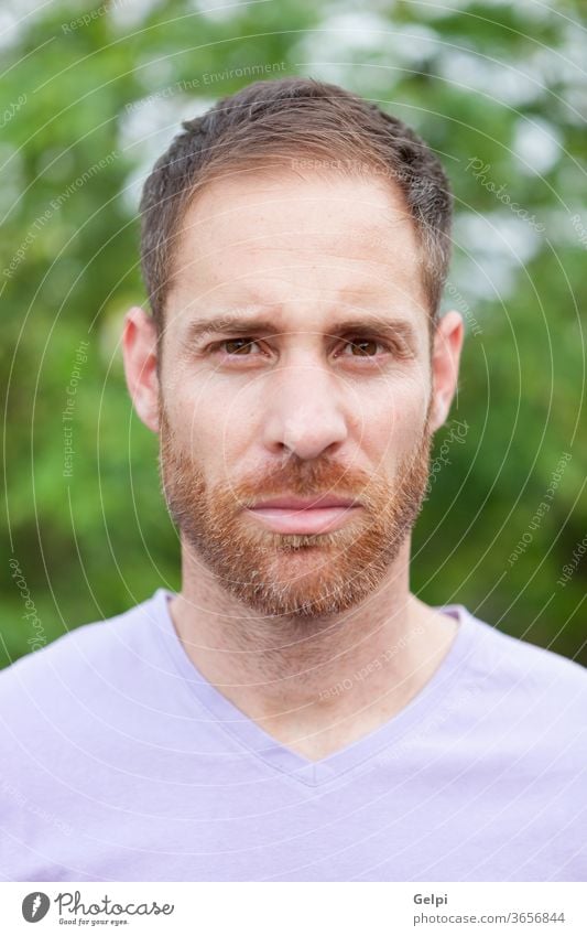 Portrait of a casual bearded man in a park male young handsome model guy fashion pensive think serious portrait denim attractive people adult person confident