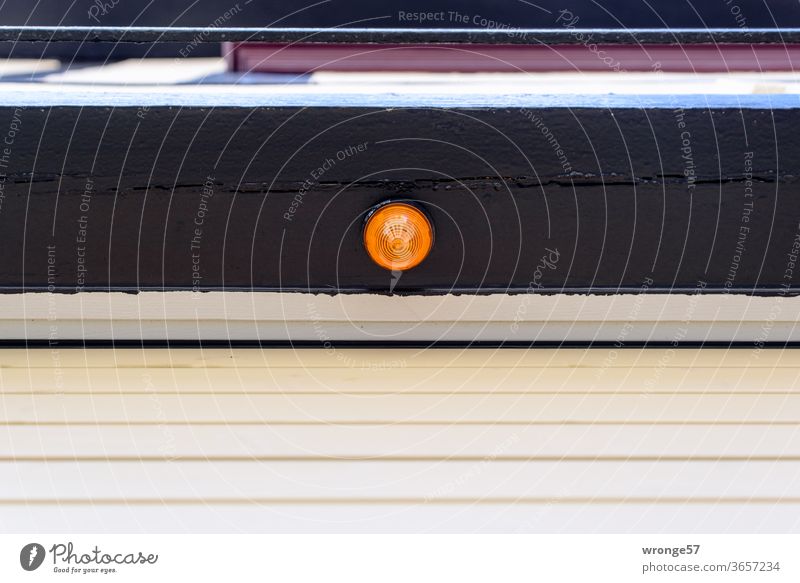 Orange signal lamp on a bar above a closed automatic garage door Garage door Automatic Electrical appliance Deserted Exterior shot Colour photo Day