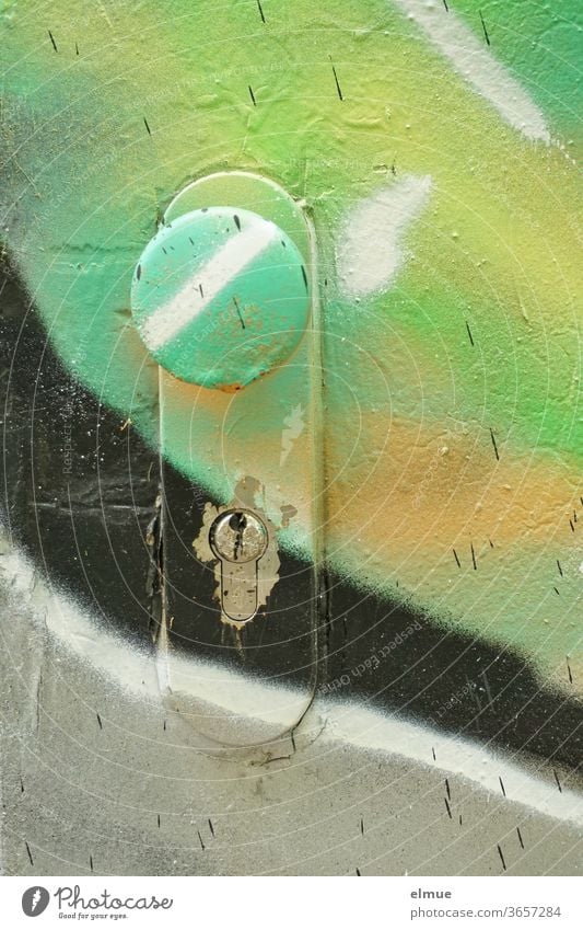 door sprayed with different colours - focus on door knob and door lock sprayer Graffiti Vandalism Doorknob variegated Colour Damage to property Spray