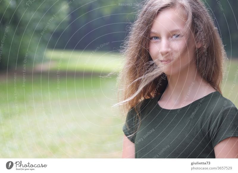 Portrait of a smiling girl with wind in her hair in the park portrait Half-profile motion blur Shadow Light Day Exterior shot Colour photo Puberty Emotions