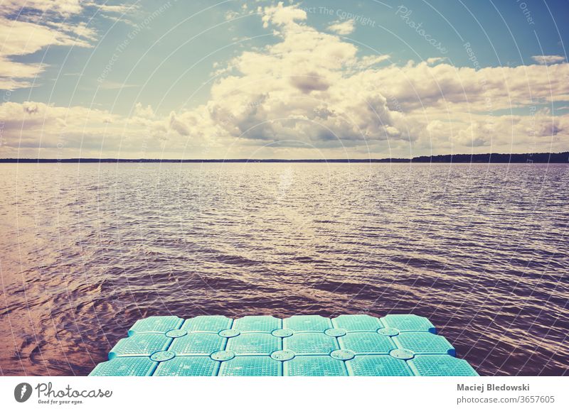 Floating plastic pier on water. floating deck lake sea nature instagram effect relax toned filtered cloud sky cloudscape weather sunlight photo sunny nobody