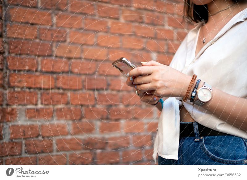 Side view of a close up of an unrecognizable woman using her smartphone alone attractive beautiful beauty cellphone city communication commute device female