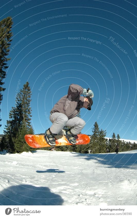 Board 4 Snowboard Winter sports Jump Winter vacation Sports Mountain Sun Snowboarding Snowboarder Shadow Tall Blue sky Exterior shot Colour photo Orange