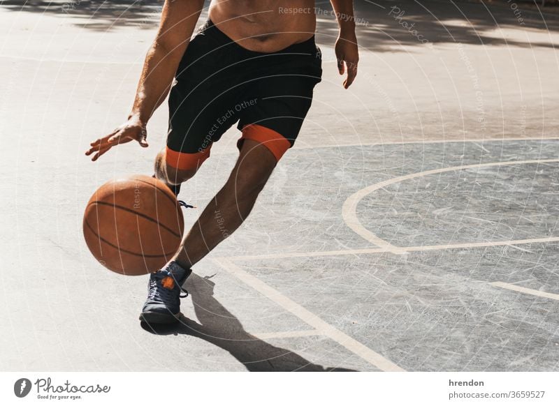 Focused cute boy athlete leads the ball in a game of basketball. A