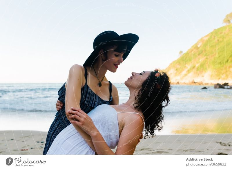Unrecognizable lesbian couple embracing and kissing on sandy sea coast women love sensual relationship romance beach honeymoon lgbt homosexual same sex