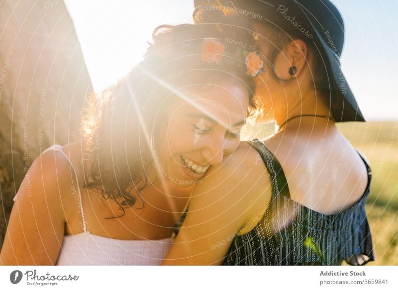 Delighted lesbian couple cuddling during sundown homosexual hug sunset women summer together relationship stroll girlfriend affection embrace close date lgbt