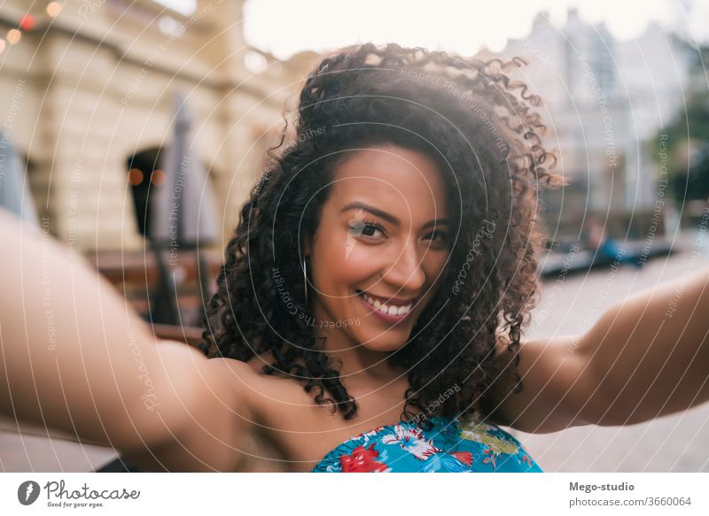 Afro american woman taking a selfie in the city. people afro portrait fun cool smile curly hair style joyful laughing modern outdoor ethnicity stylish cute