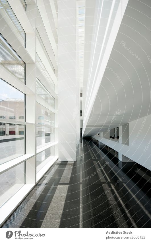 Modern building with symmetrical windows and dark floor architecture corridor symmetry contrast wall empty modern style geometry sunlight narrow urban gray