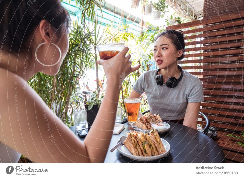 Asian female friends on terrace in cafe enjoy weekend summer women tasty dessert drink together ethnic asian delicious chill refreshment beverage relax young