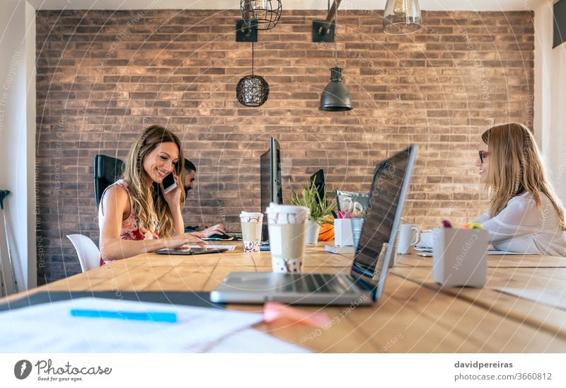 People working in a coworking office businesswoman coworkers teamwork phone communication talking people job professional young workplace industrial decor style