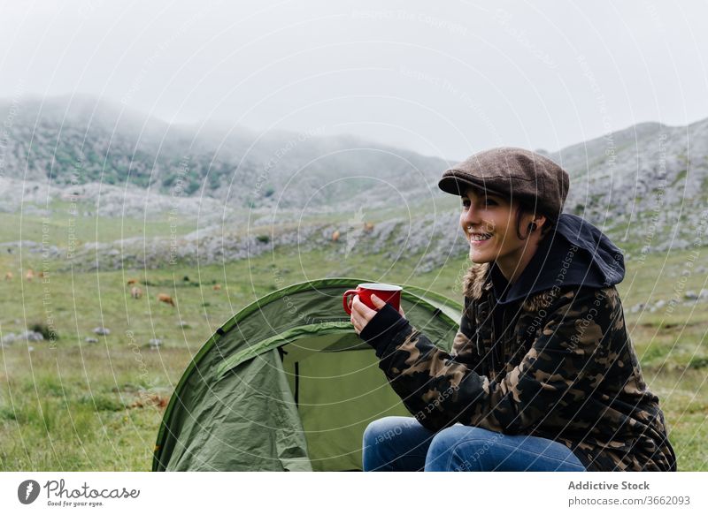 Woman in outerwear near camping tent in nature woman highland content relax traveler morning wanderlust freedom landscape harmony joy casual countryside cold