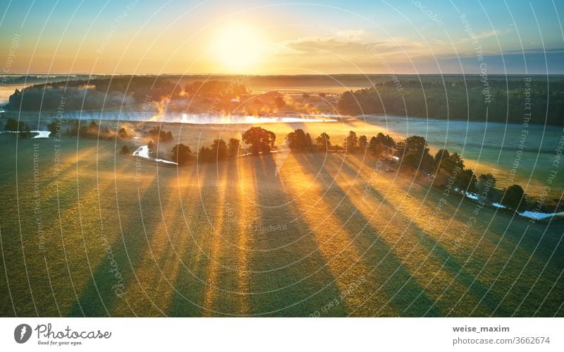 First sunrays over green meadow and field. Sunny summer calm morning panorama. fog river nature landscape sunrise cloud tree background environment mist aerial