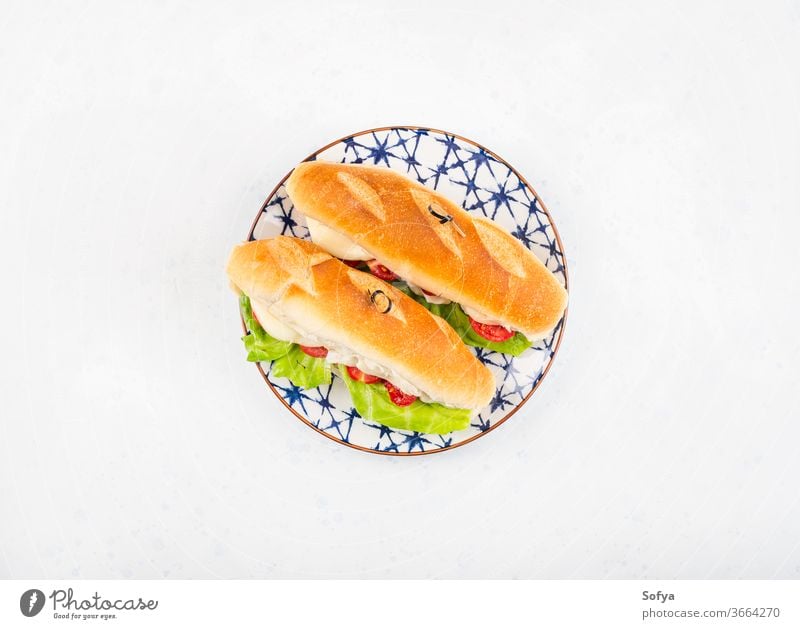 Baguette sandwich with tomatoes and cheese baguette submarine bread lunch hoagie flat lay melted vegetable top view salad lettuce wooden food white board napkin