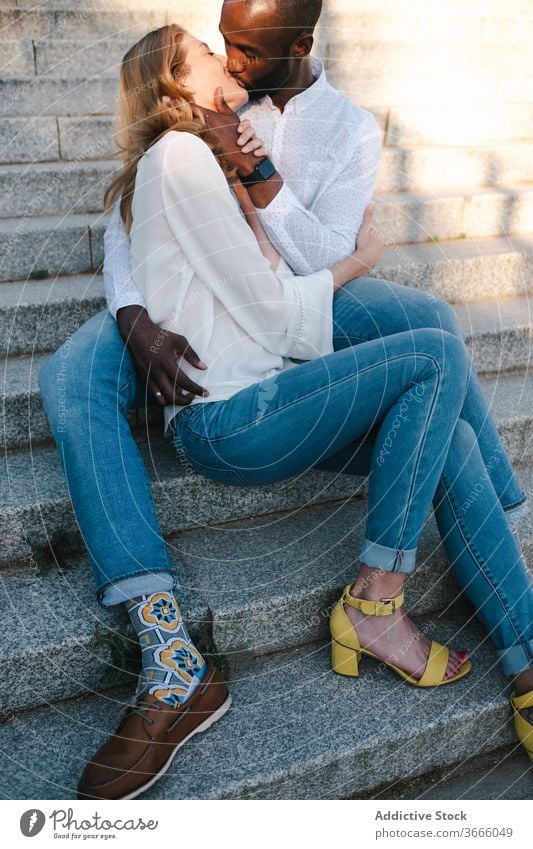 Happy diverse couple kissing on street bonding romantic positive relationship love happy affection embrace modern casual urban city lifestyle multiethnic