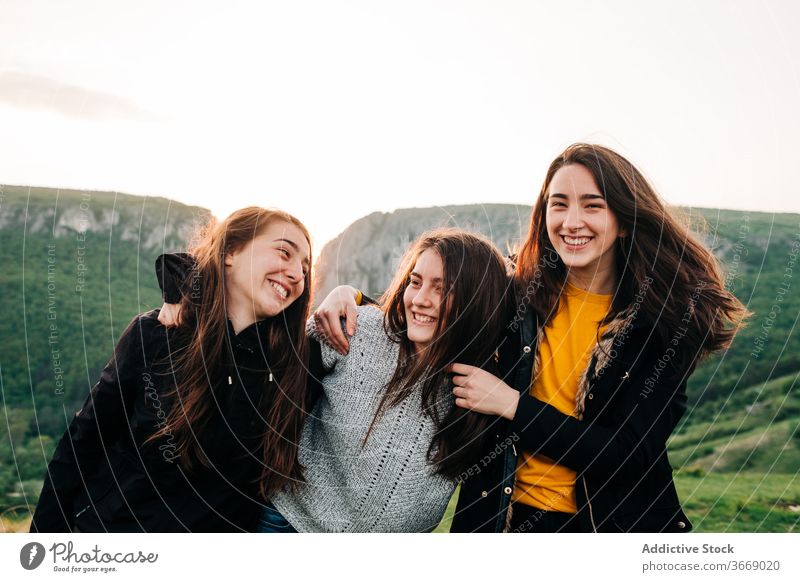 Cheerful female friends hugging in mountains together vacation friendship girlfriend unity highland transylvania romania saint george amazing embrace happy