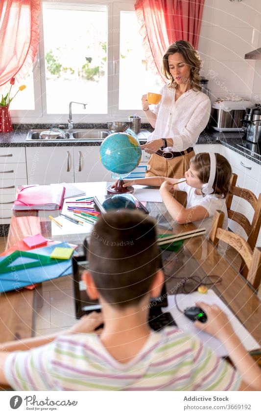 Teacher showing globe to boy in headset while studying geography teacher class pupil education knowledge lesson headphones learn home demonstrate house comfort