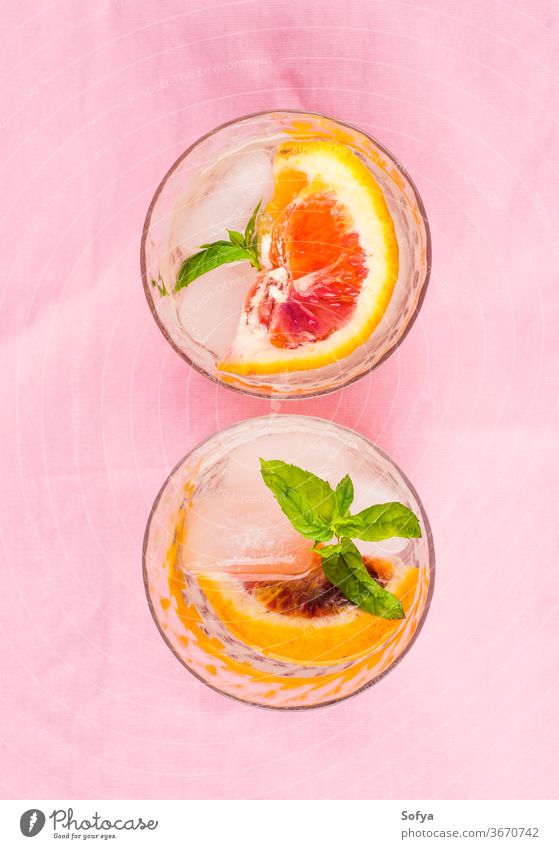 Summer iced citrus drink with mint on pink napkin water cocktail lemonade infused detox blood orange lime fruit summer juice mocktail soda sweet home made slice