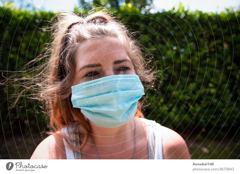 Young woman wearing facemask, safety mask for COVID-19, Coronavirus. Portrait of adult girl outside. Concept for flu or coronavirus infection young epidemic
