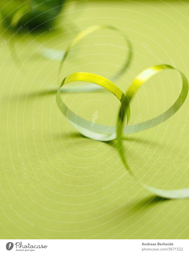 twisted red silk ribbon, yellow background - a Royalty Free Stock Photo  from Photocase