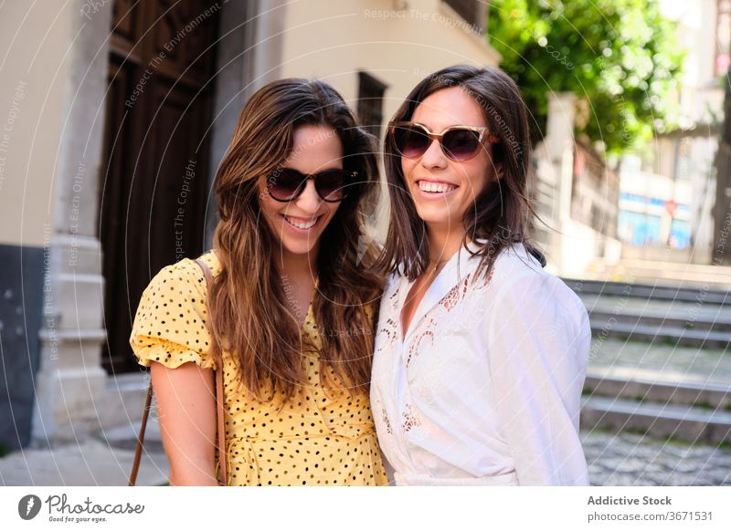 Two happy young women friends hugging in the street. - a Royalty