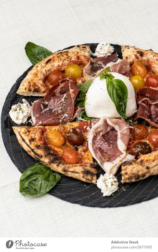 Tasty sliced tomato pizza with prosciutto and mozzarella ham basil delicious italian food gourmet dish tasty meal cheese delectable traditional palatable yummy