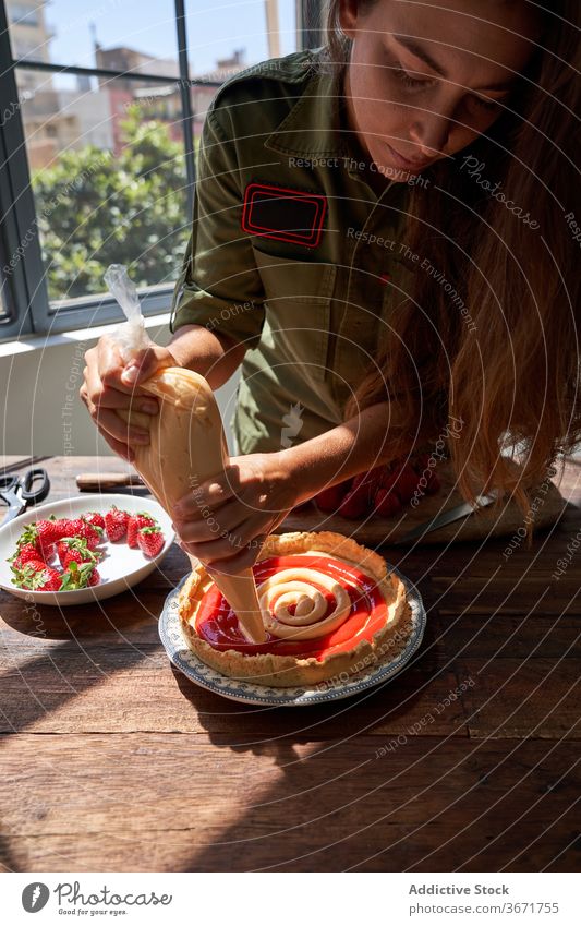 Crop woman decorating cake with cream piping bag squeeze pie cook decorate confectionery homemade female delicious table housewife food yummy palatable sweet