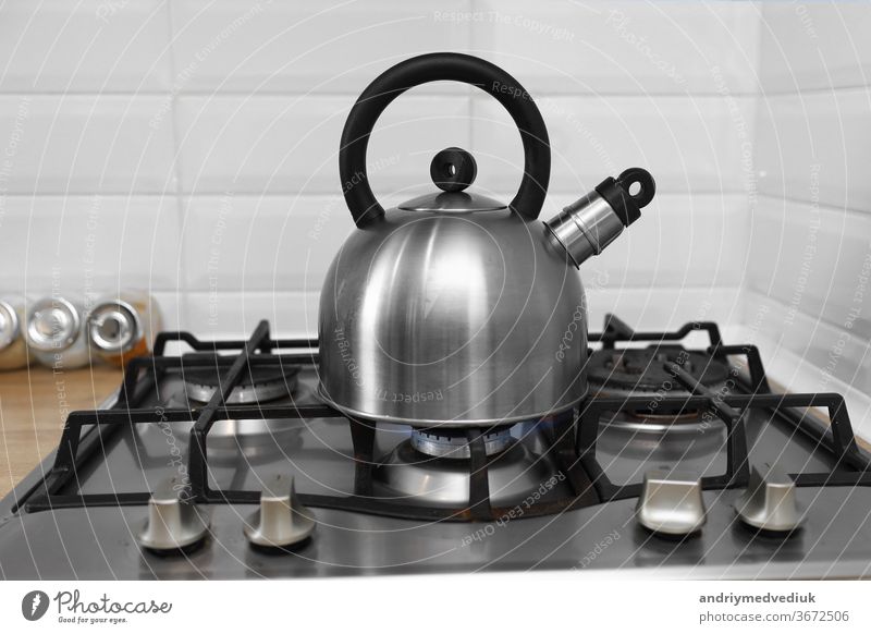 metal kettle on a gas stove. kettle boiling on a gas stove. Focus on a spout. Tea kettle with boiling water on gas stove steam steel kitchen hot cooking
