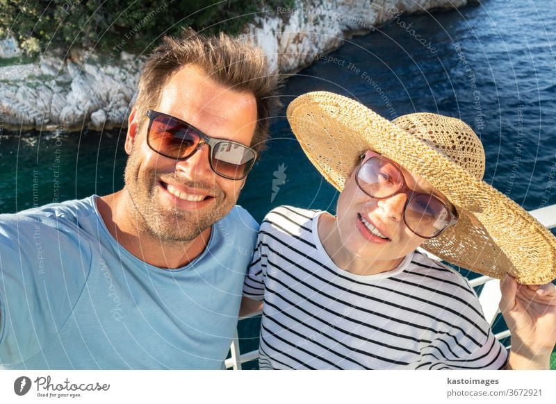 Beautiful, romantic caucasian couple taking selfie self portrait photo on summer vacations traveling by cruse ship ferry boat. lifestyle love straw hat guy girl