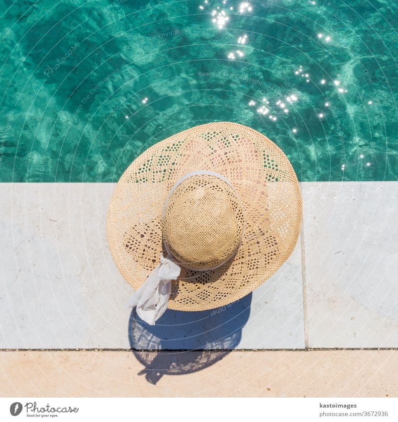 Woman wearing big summer sun hat relaxing on pier by clear turquoise sea. water leisure beauty girl person blue tan body young spa pool woman beach holiday