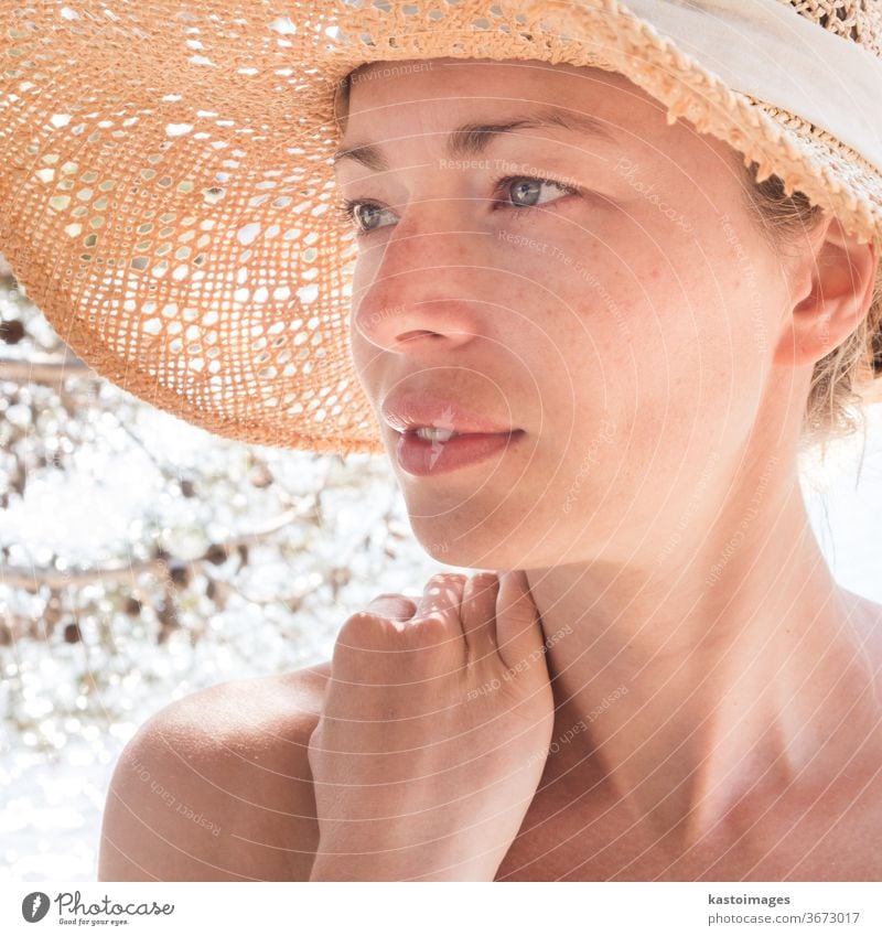 Close up portrait of no makeup natural beautiful sensual woman wearing straw sun hat on the beach in shade of a pine tree. summer person female lady young sea