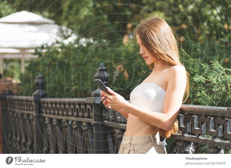 Young stylish pretty woman with smartphone in the city streets. young hat europe technology happy girl female urban people smiling casual lifestyle cellular