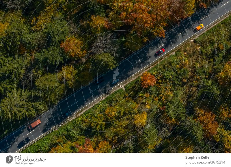 Vertical view from a drone at a autumn road. car speed fall diagonal inspiring sun nature landscape awesome line wonderful copter traffic bavaria breathtaking
