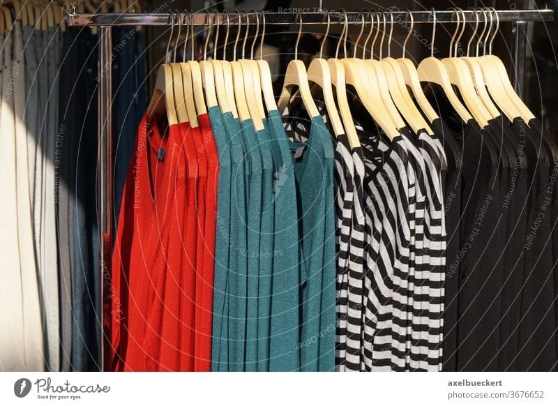 Fashionable stylish women's clothing on a hanger. Close-up of branded  clothing in a show room. Light background. Fashion retail, show room,  shopping or seasonal sale concept. Selective focus - a Royalty Free