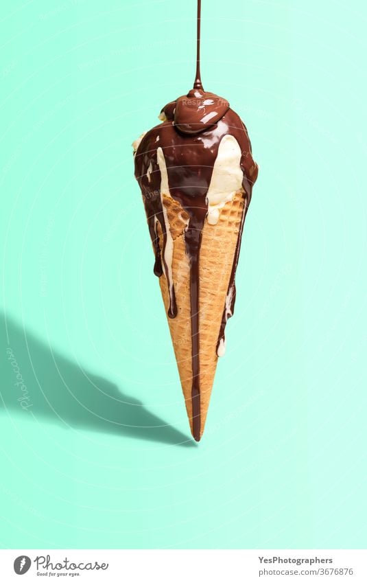 Vanilla ice cream cone with dripping chocolate. Ice cream with topping. Melted chocolate drip background bright color copy space cut out dairy delicious dessert