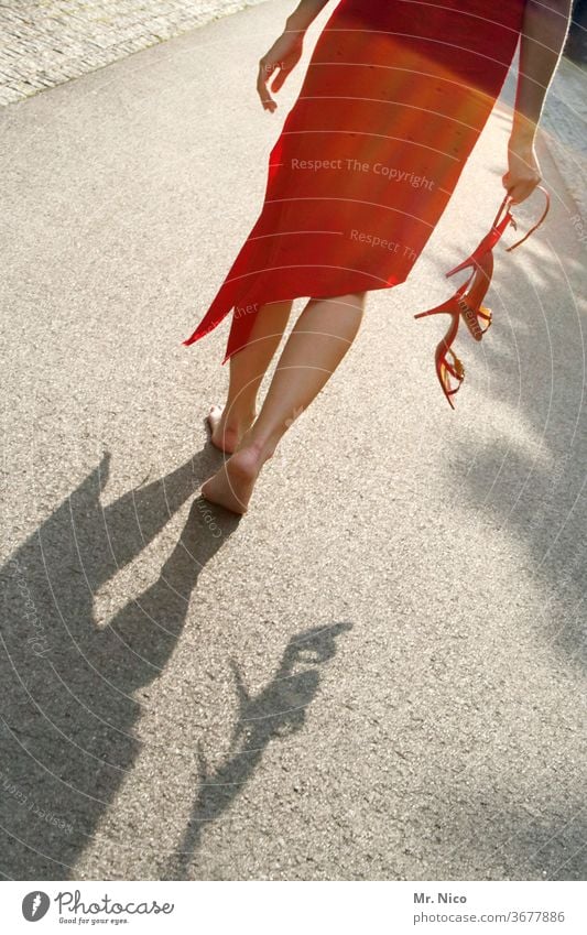 Woman in a red dress walks barefoot across the street take off one's shoes Dress Footwear Summer dress Barefoot Legs feet High heels Red Skin Calf Asphalt