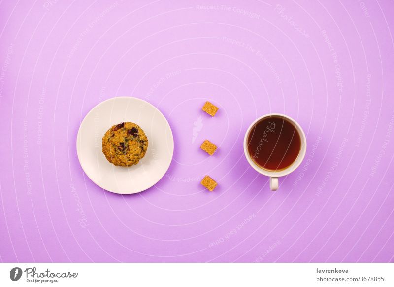 Flatlay with a blueberry muffin, cup of tea and cane sugar cubes. Breakfast concept. Violet background. fresh caffeine bakery violet drink cappuccino dessert