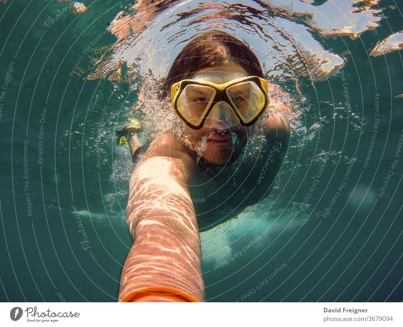 Young man with snorkel and diving mask swimming and taking a selfie under water. Travel, vacation and sports activity concept. ocean young sea underwater diver