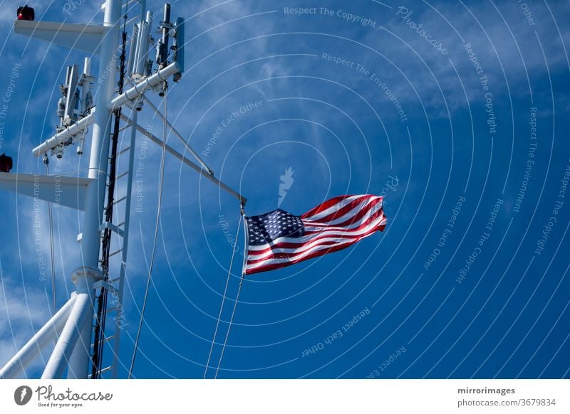 United States of America Flag Blowing in the Wind on the the deck of a large ship at sea with cell towers america american banner battleship blue boat breeze