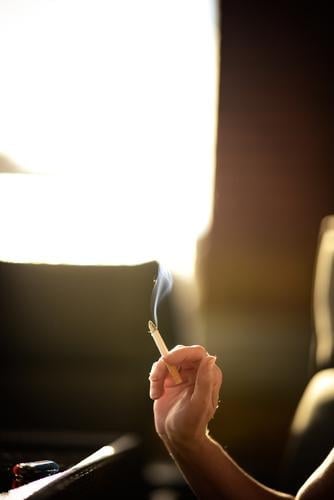 Woman holds a smoking cigarette in her hand Cigarette smoke steam Smoking Smoky Smoker Anonymous Deep depth of field Sunlight Sunbeam Yellow Addiction Nicotine