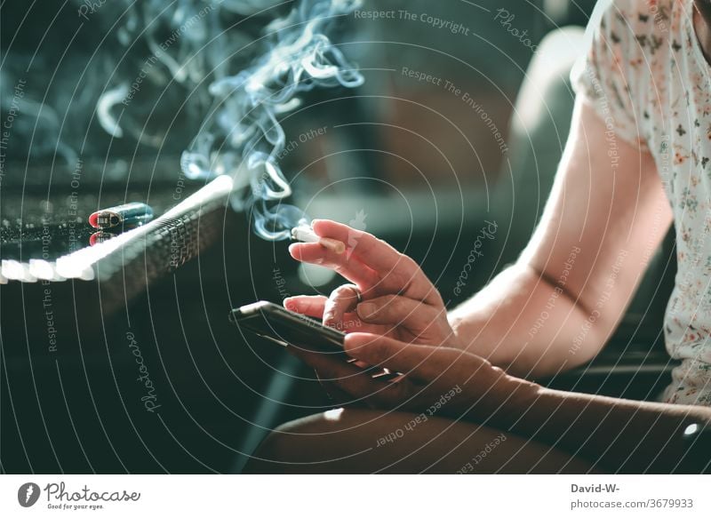 Woman with a cigarette in her hand typing on her cell phone mobile Typing by hand hands Fingers Smoking Smoke smoke Addiction Addictive behavior addictive