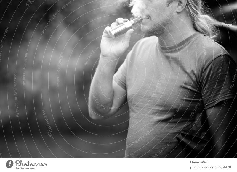 Man pulls an e-cigarette e-zigarette Cigarrete Electric Electronic Dependence drugs Addiction addictive potential addicted be dependent Black & white photo