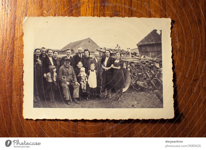 Family photo in the countryside. All standing around the grandfather , and grandmother . In the background a woodpile . Very old photo of the family in the country. East Prussian impressions