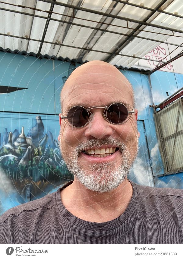 old man in blue Man Only one man portrait Adults Sunglasses Bald or shaved head Face Graffiti Wall (building) Facade Blue Facial hair Laughter